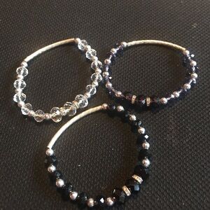 Set of three beaded bracelets. One black one clear and one purple.